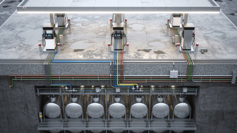 Vue technique d’une station-service moderne montrant les cuves souterraines, les pompes et les îlots de distribution, dans un aménagement industriel détaillé.